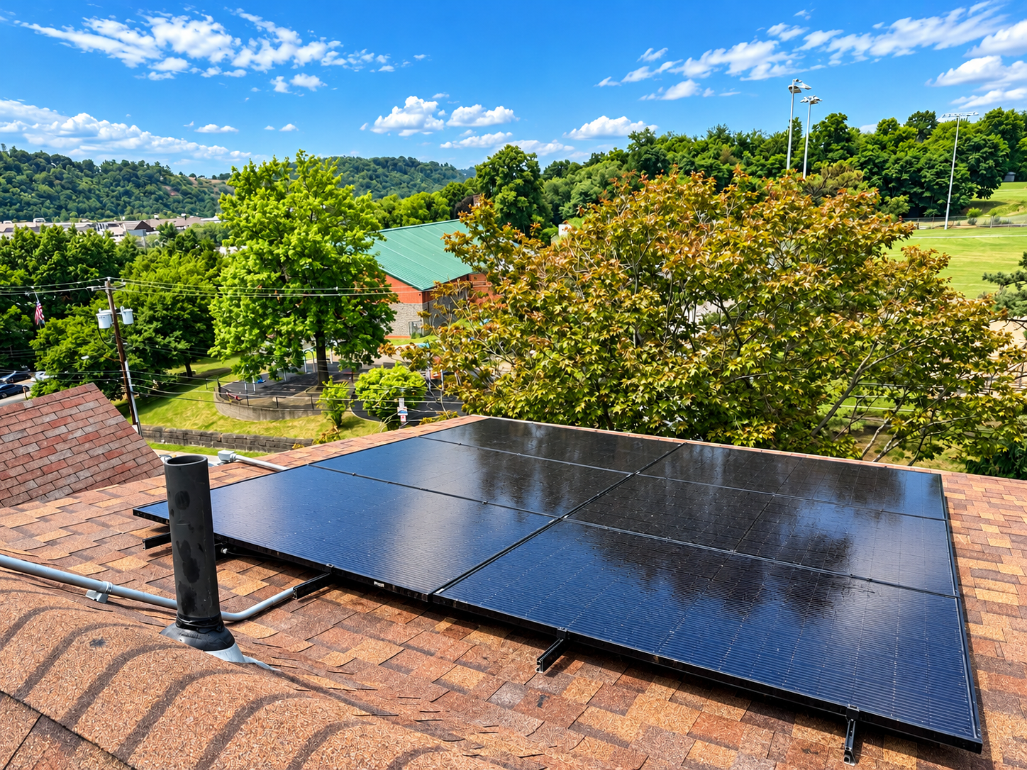 Established residential solar array on a brown-shingle roof surrounded by mature trees