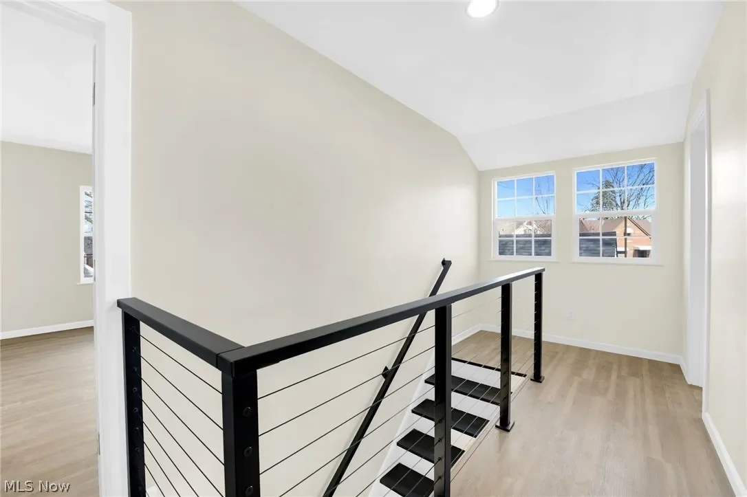 Staircase: modern black cable-style railing along the stairs, with natural light from the window.