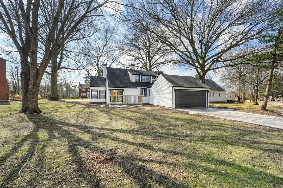 Parma, Ohio: wide view of the renovated home with its attached garage and front porch, seen across the yard.
