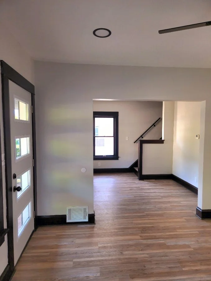 Completed living room renovation with dark trim and wood flooring
