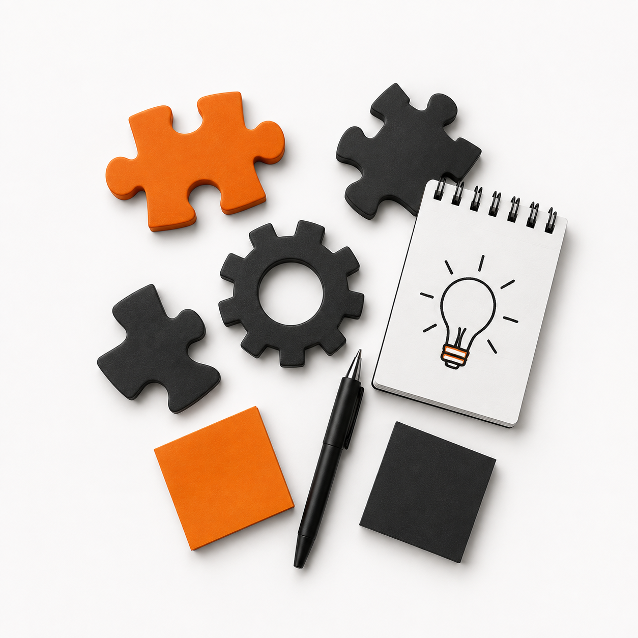 Schwarz-orange Puzzle-Teile, eine schwarze Zahnradtasche, ein Notizbuch mit Glühbirnenzeichen, ein schwarzer Stift, zwei Klebezettel, und eine Skizze einer Glühbirne auf weißem Hintergrund.