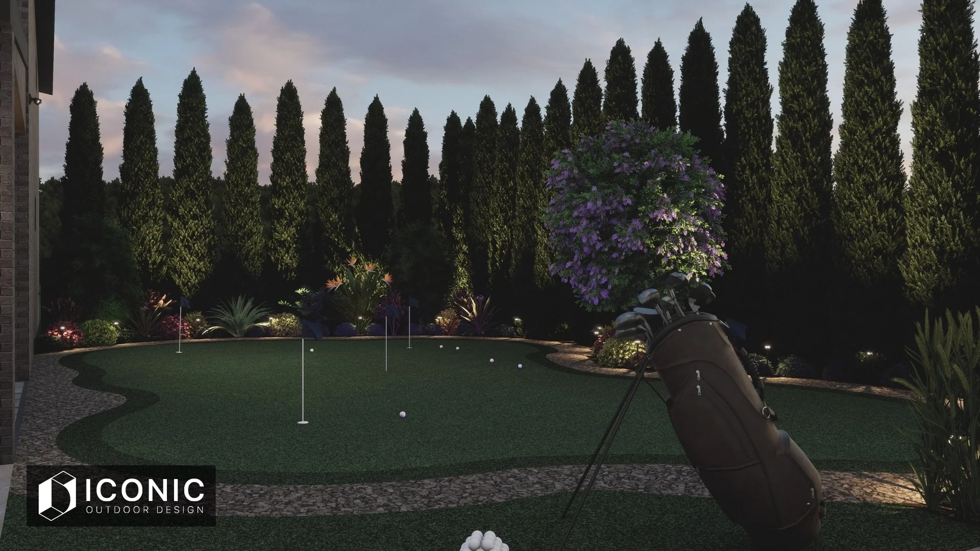 Night view of a backyard putting green with golf clubs and golf balls, surrounded by landscaped plants and trees, under outdoor lighting, with a large flowering tree and tall cypress trees in the background.