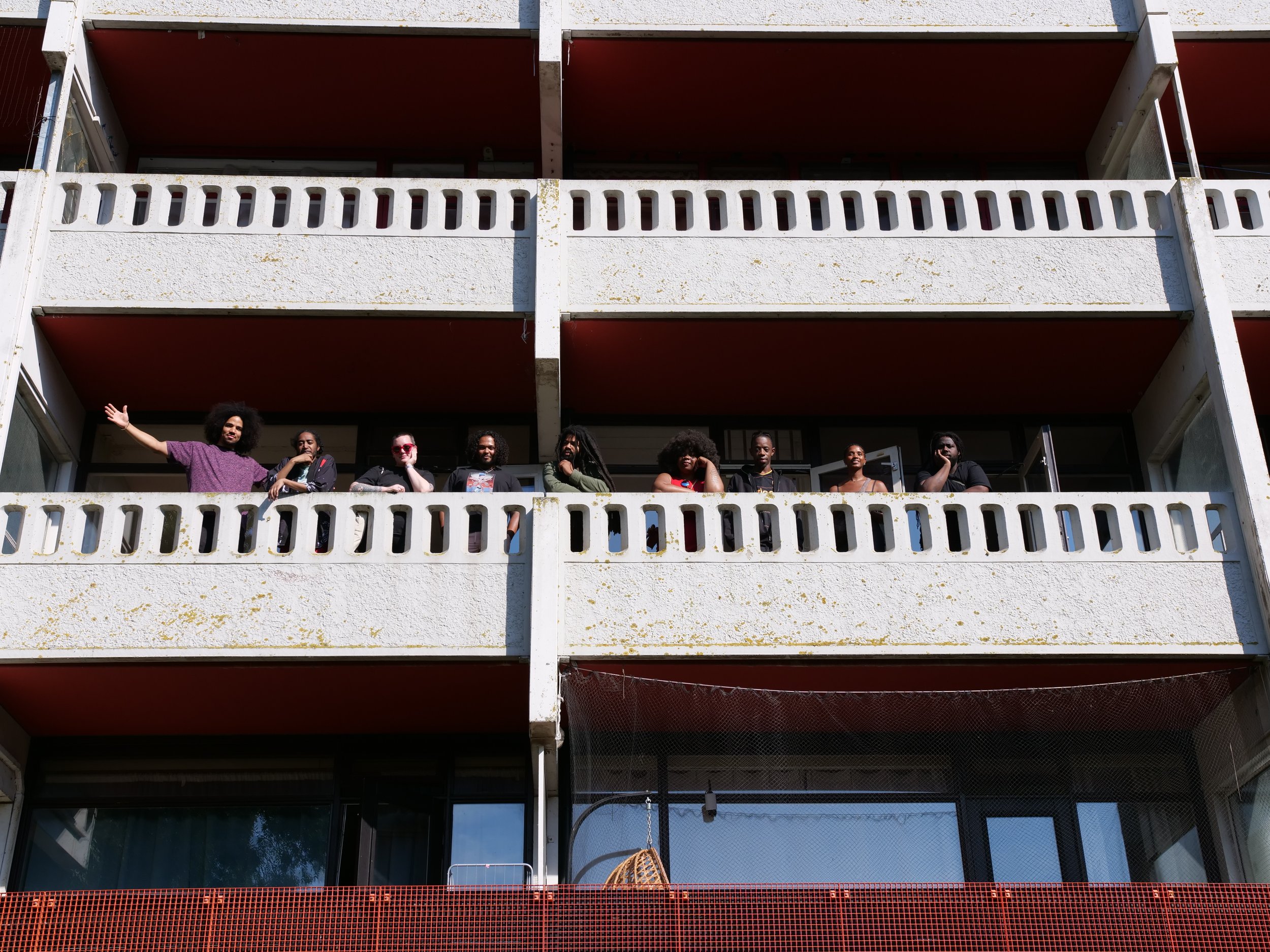 Tien bezoekers van FILAppartement mensen staan op het balkon.