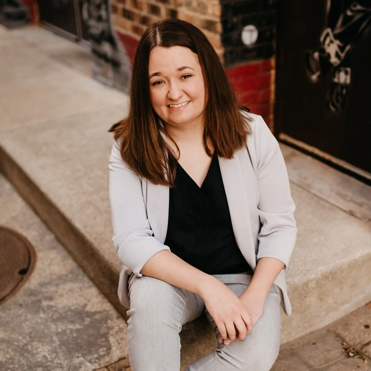 Moriah Wallis, founder of Lamp Ledgers Accounting, seated outside a brick building in South Bend.