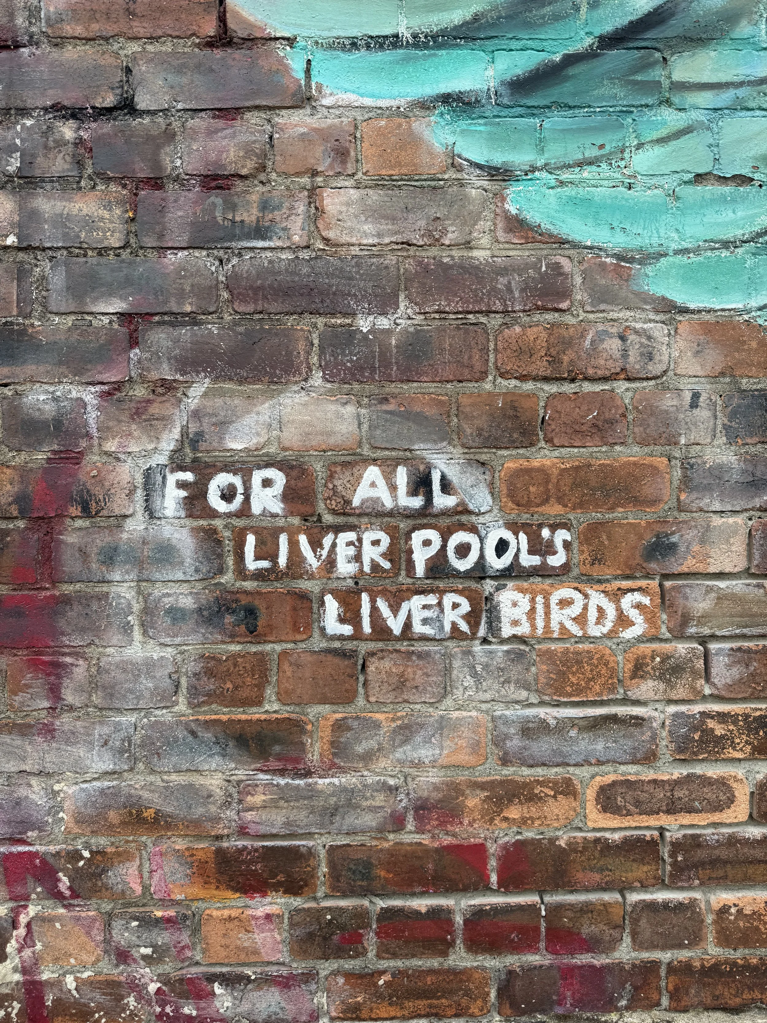 Graffiti on a brick wall reading 'For all my Liverpool fans' in white paint, with some teal-colored artwork above. Taken by Nook booth Photo Booth.
