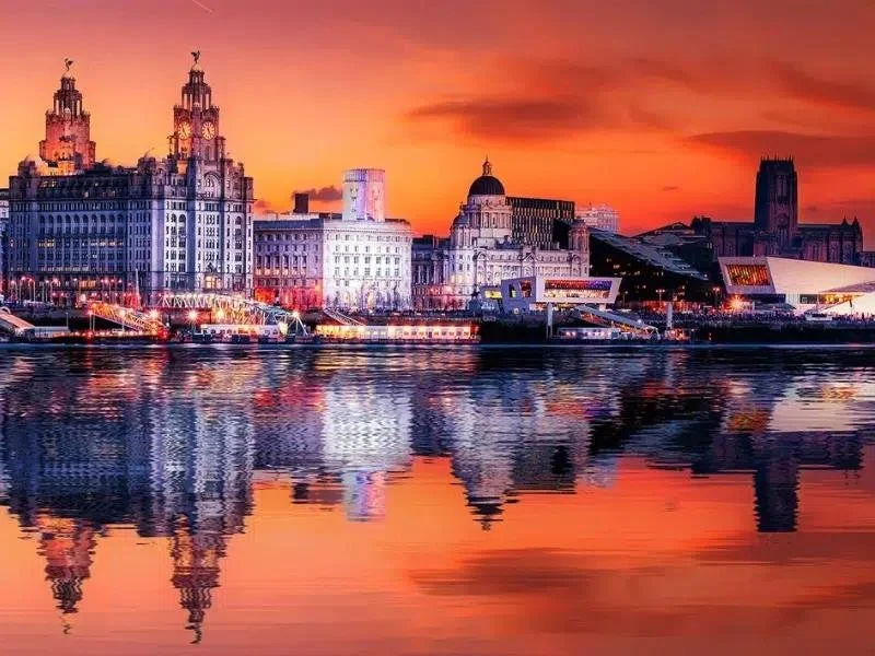 City skyline at sunset with illuminated buildings reflected in the water. Taken by Nook booth Photo Booth.