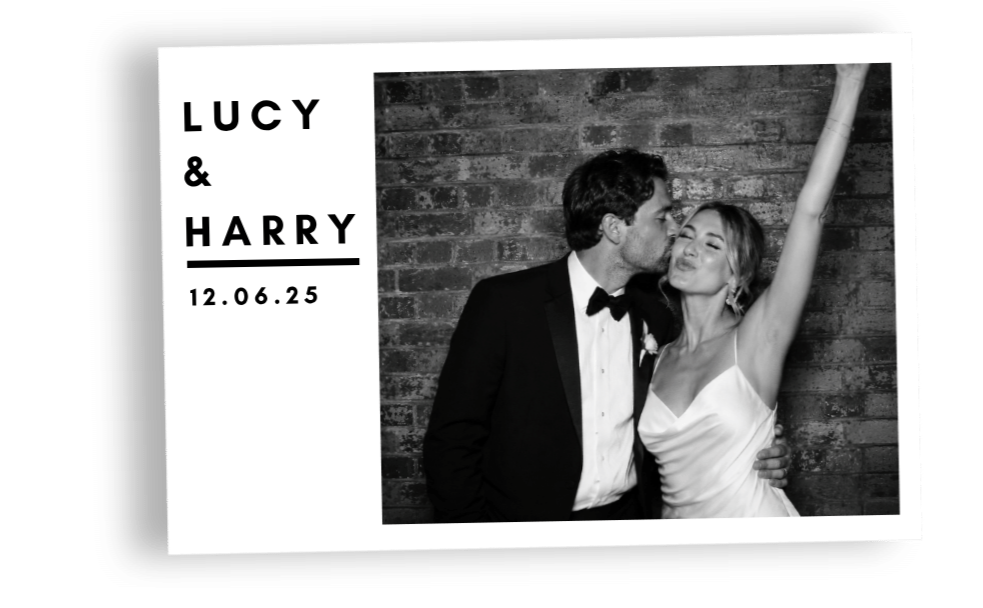 Black and white photo of a couple at their wedding, with the man in a tuxedo kissing the woman on the cheek, who is wearing a white dress with her arm raised, against a brick wall. The left side has text with their names "LUCY & HARRY" and the date "12.06.25.