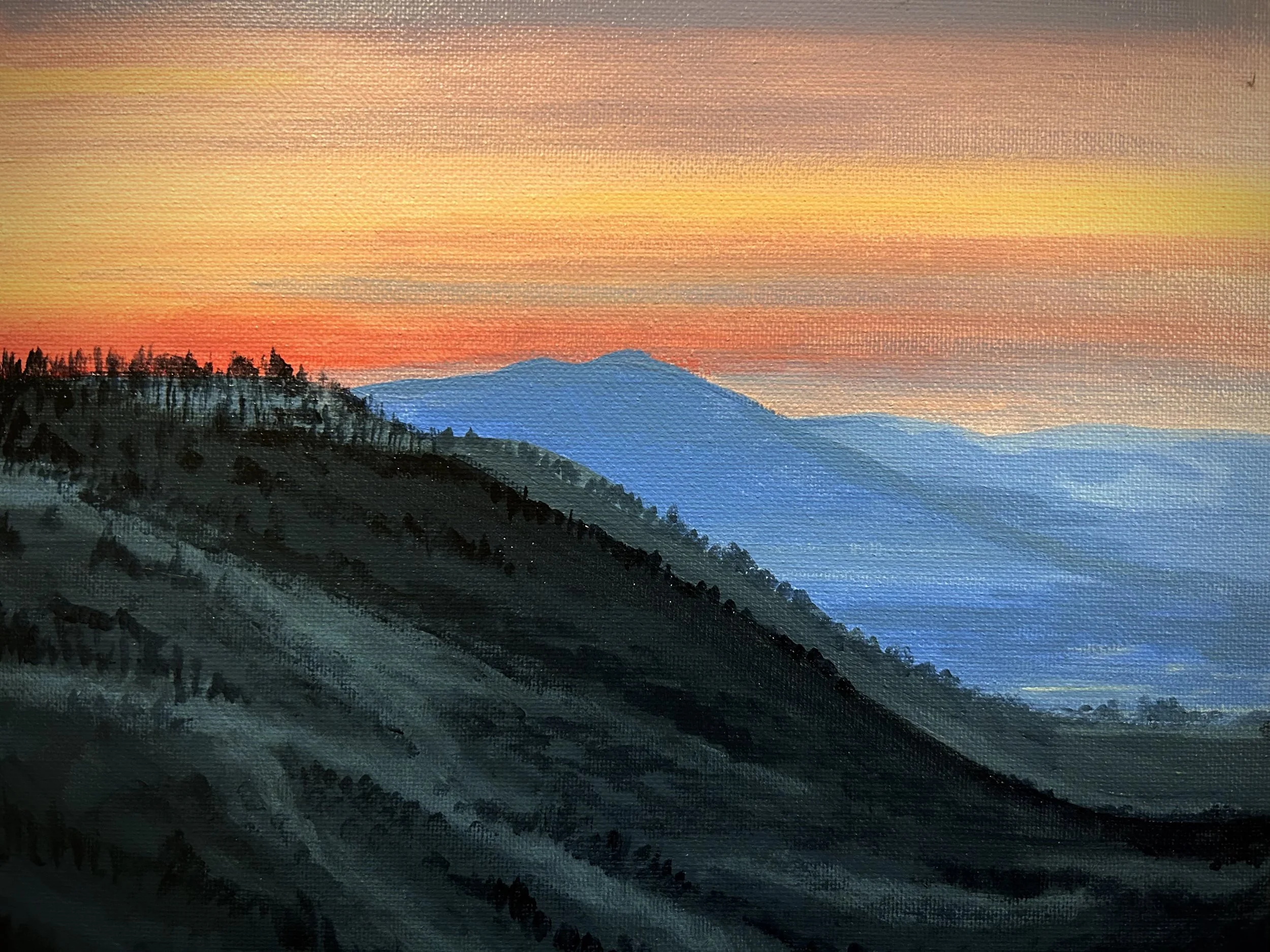 Painting of a mountain landscape during sunset with a dark ridged foreground, blue mountains in the middle ground, and a colorful sky with shades of orange, pink, yellow, and purple.