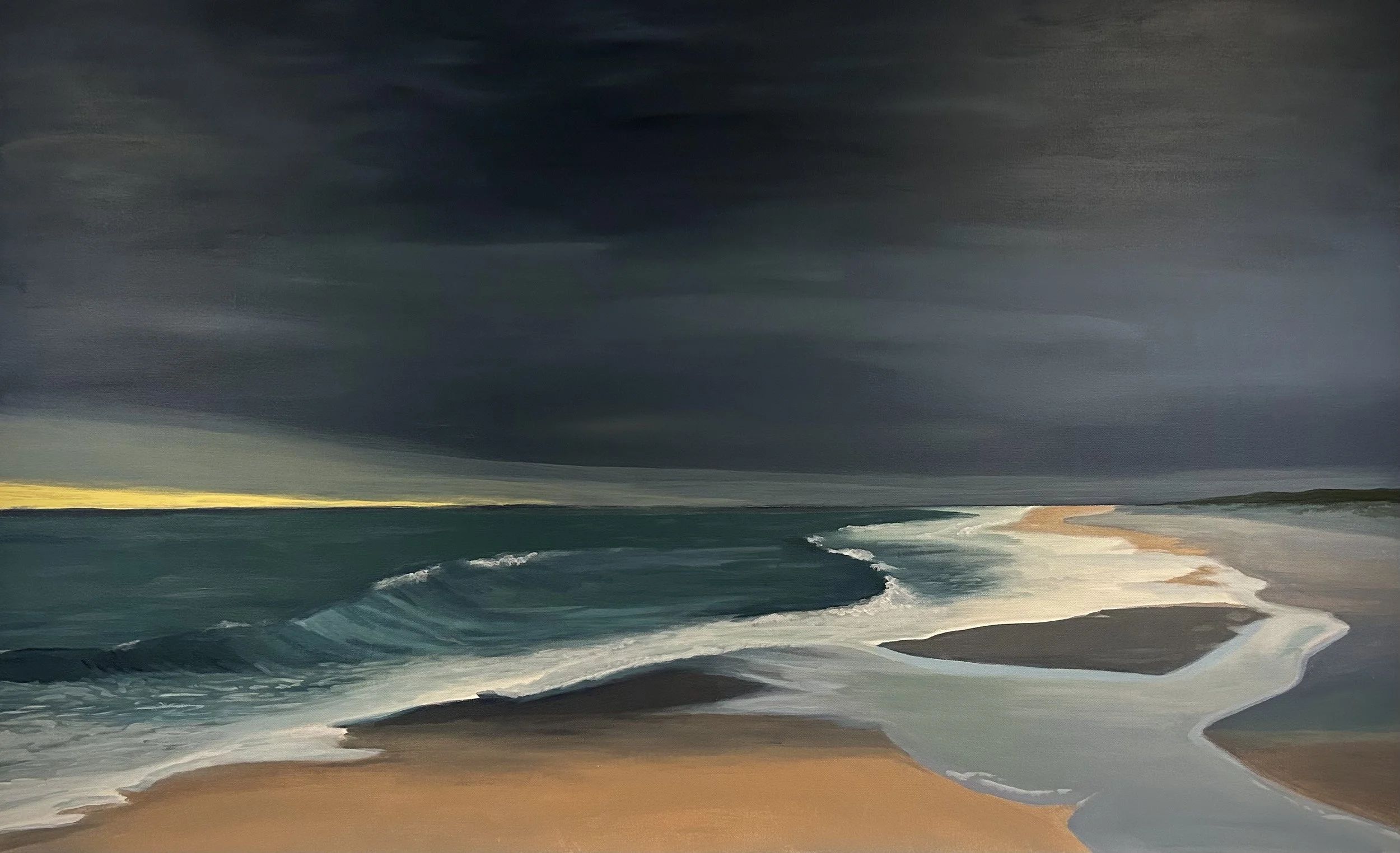 Cloudy storm approaching a beach with waves and sandy shoreline
