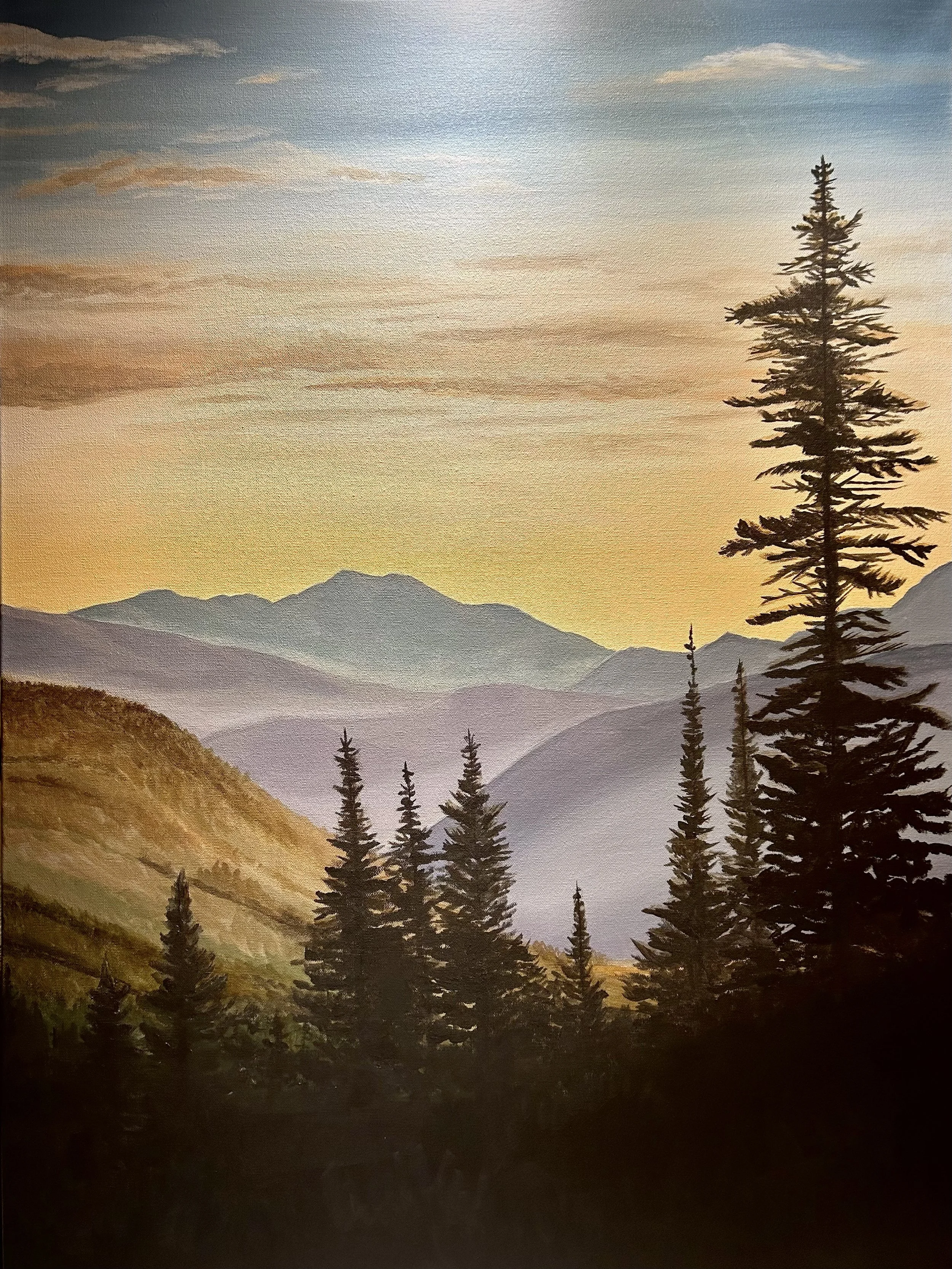 A painting of a mountainous landscape at sunrise or sunset with evergreen trees in the foreground and distant mountain peaks with a colorful sky.