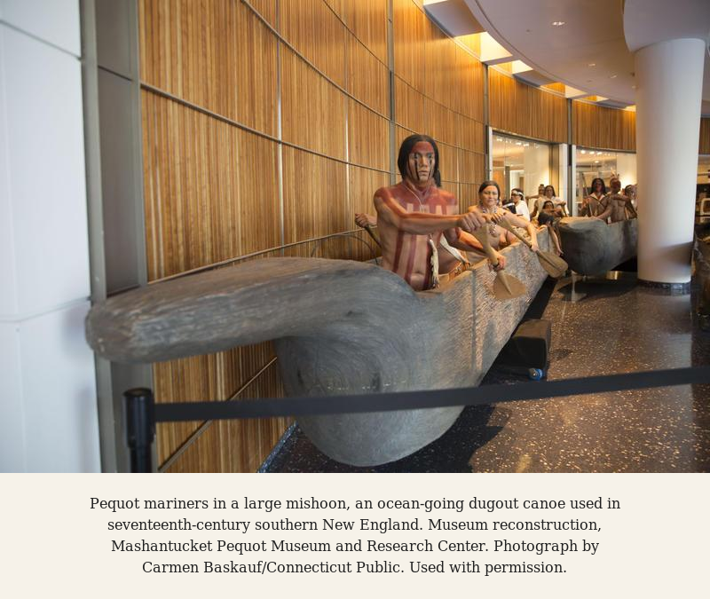 Mariner statues in a large replica of a historic dugout canoe at the Mashantucket Pequot Museum and Research Center, with visitors in the background.