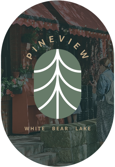 People at a market stand under a red awning, with flowers on display, at PINEVIEW White Bear Lake.