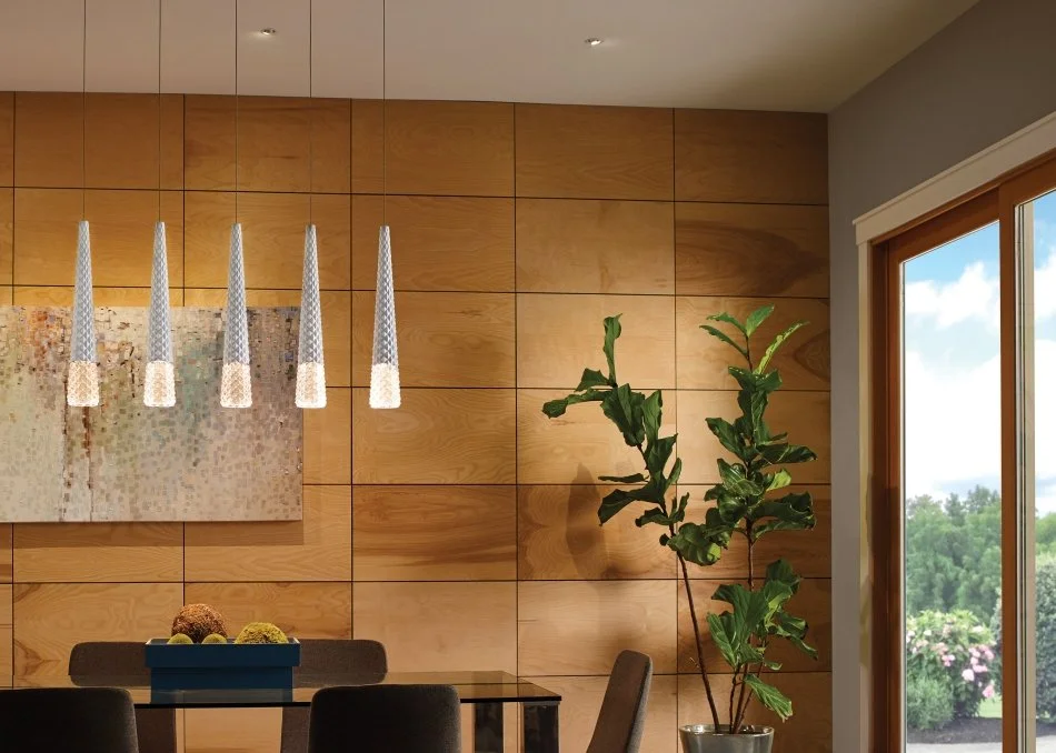 Modern dining room with wood-paneled walls, pendant lights, indoor plants, dining table, and garden view through a window