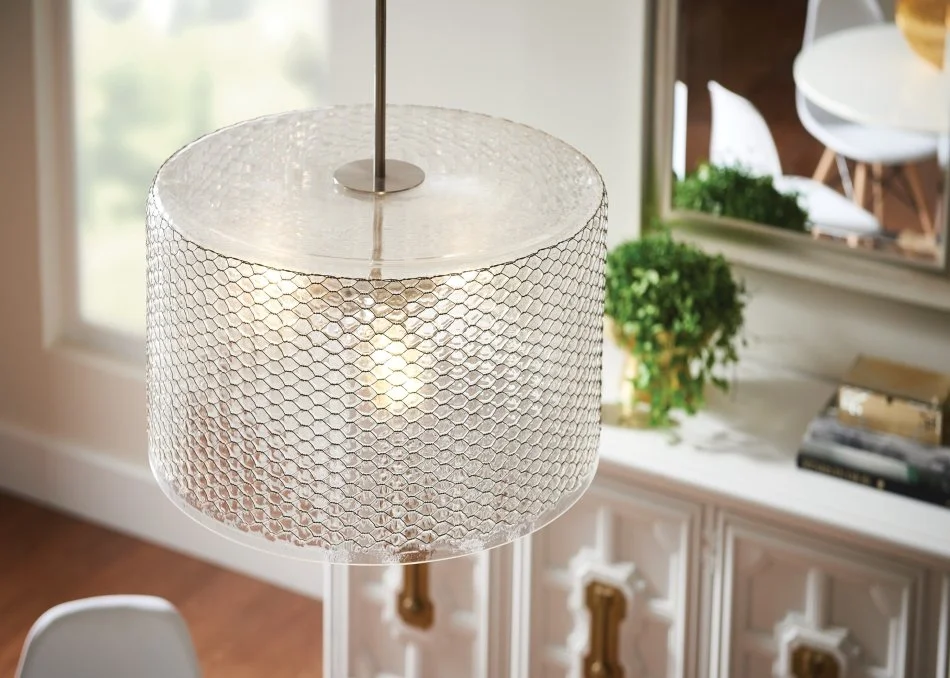 Modern round pendant light with a textured glass shade in a bright dining room