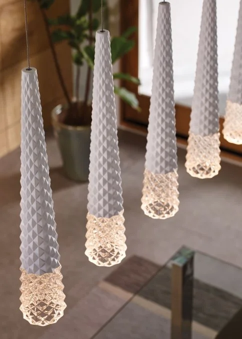 Four white textured pendant lights with glowing crystal-like lower sections hanging indoors