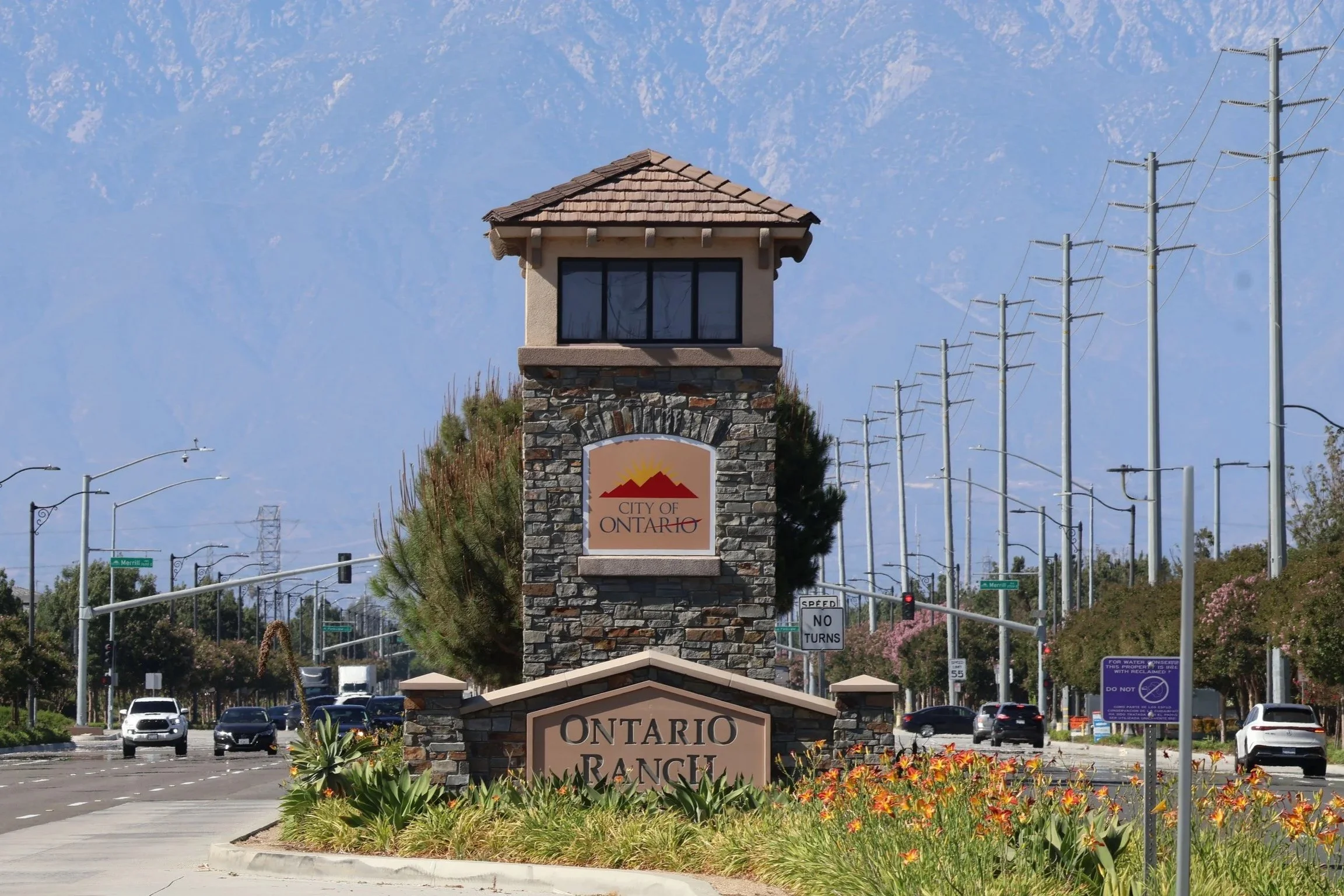 Ontario, California welcome sign with the San Gabriel Mountains visible in the distance.