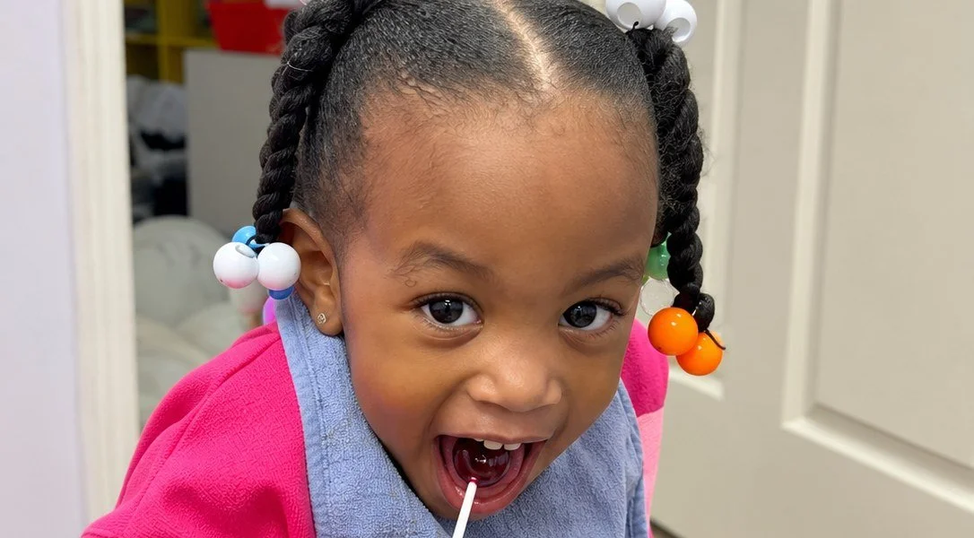 A smiling toddler in a Smarty Pants classroom