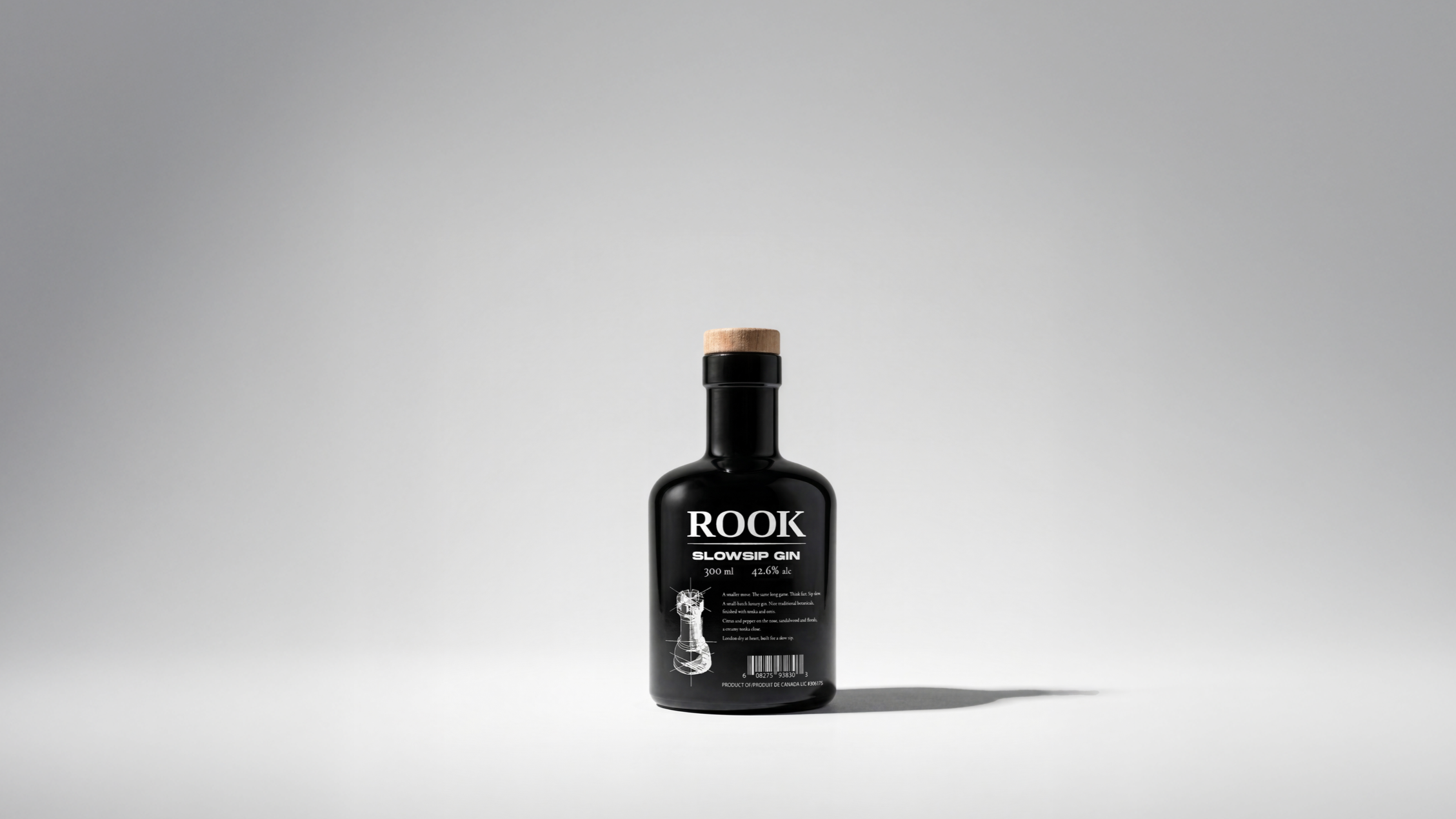 Rook Slowsip Gin bottle by Pheiffer — gloss black glass with a wood-topped cork and serif wordmark.
