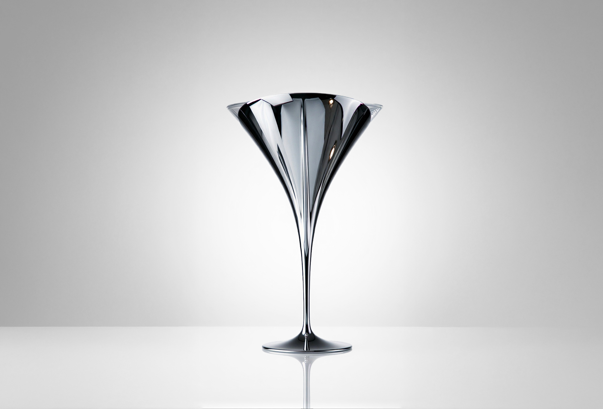 Close-up of the Tulip Martini glass by Pheiffer, showing the polished chrome bowl and the curve where it meets the stem.