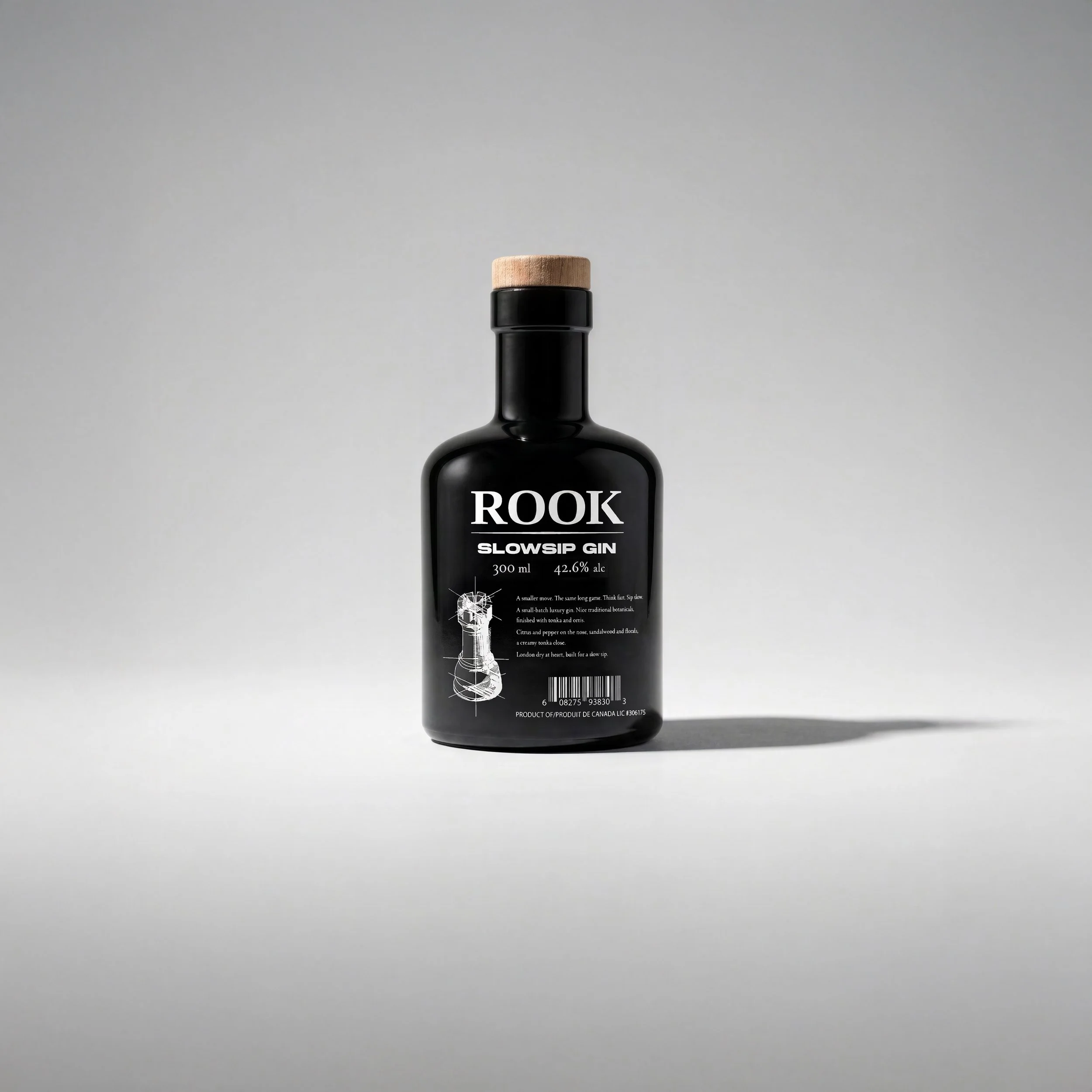 Rook Slowsip Gin bottle by Pheiffer — a gloss black 300ml bottle with a natural wood-topped cork, serif ROOK wordmark, and a fine line drawing of a rook chess piece