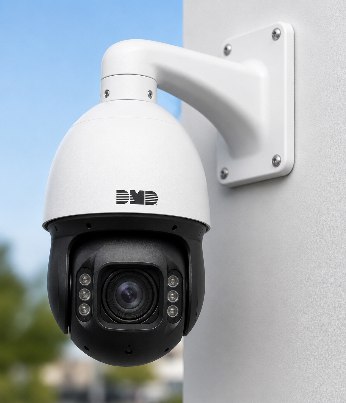 A DMD security camera mounted on a white wall with a background of blue sky and blurred greenery.