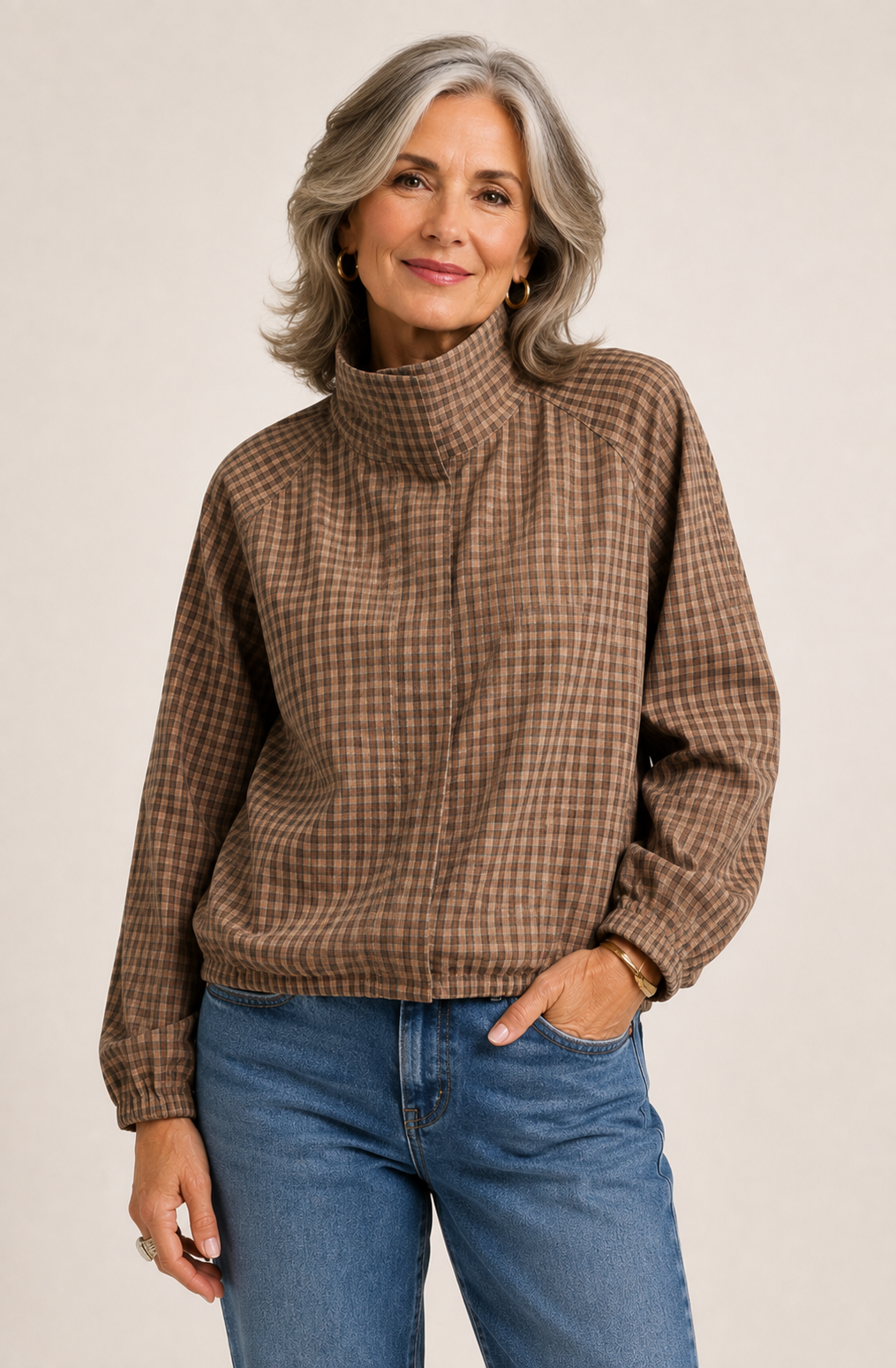 Woman wearing a checkered plaid fall jacket with jeans.