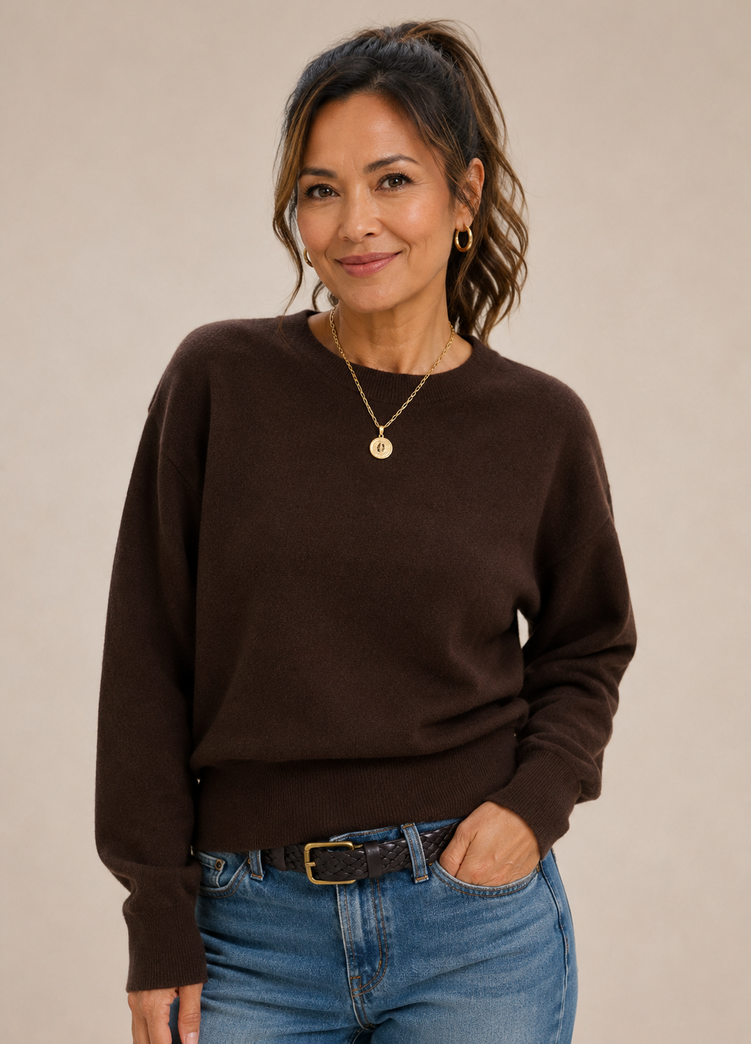 Woman wearing a dark brown sweater with jeans.