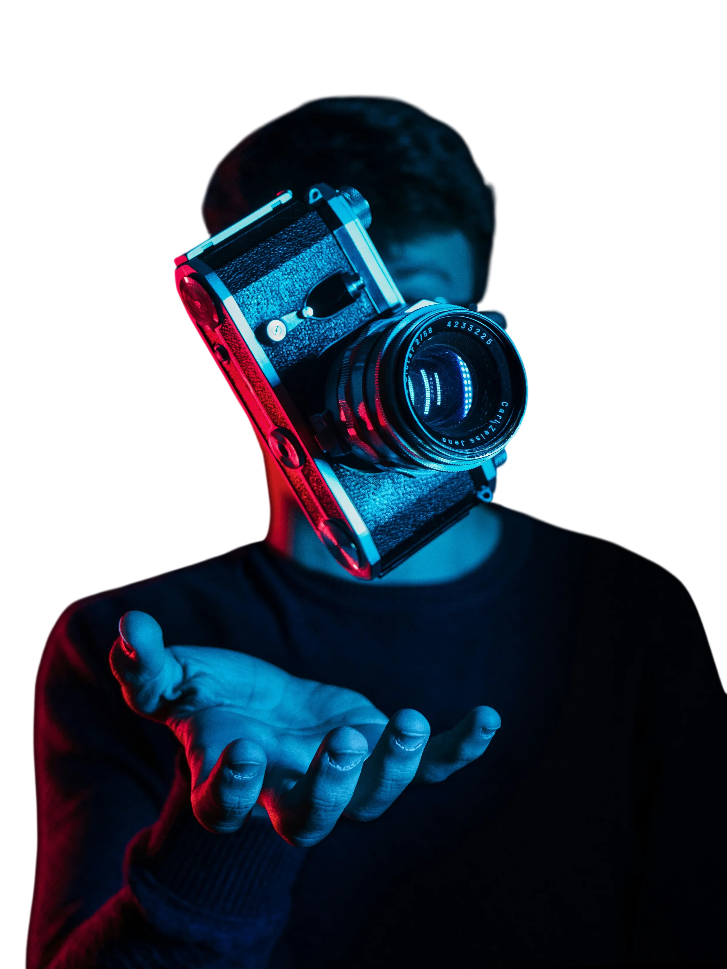 A person holding a vintage camera with blue and red neon lighting, with their face partially obscured in the background.