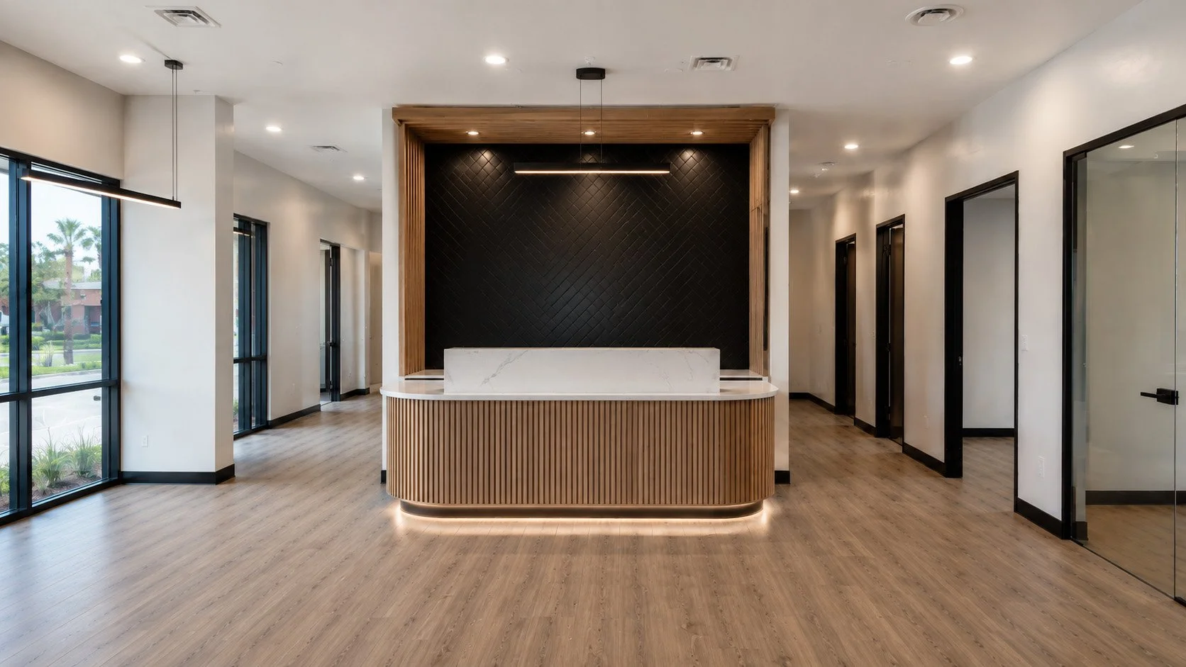 Modern reception area with a curved wooden desk, black textured wall, marble counter, wood accents, large windows, and glass doors.