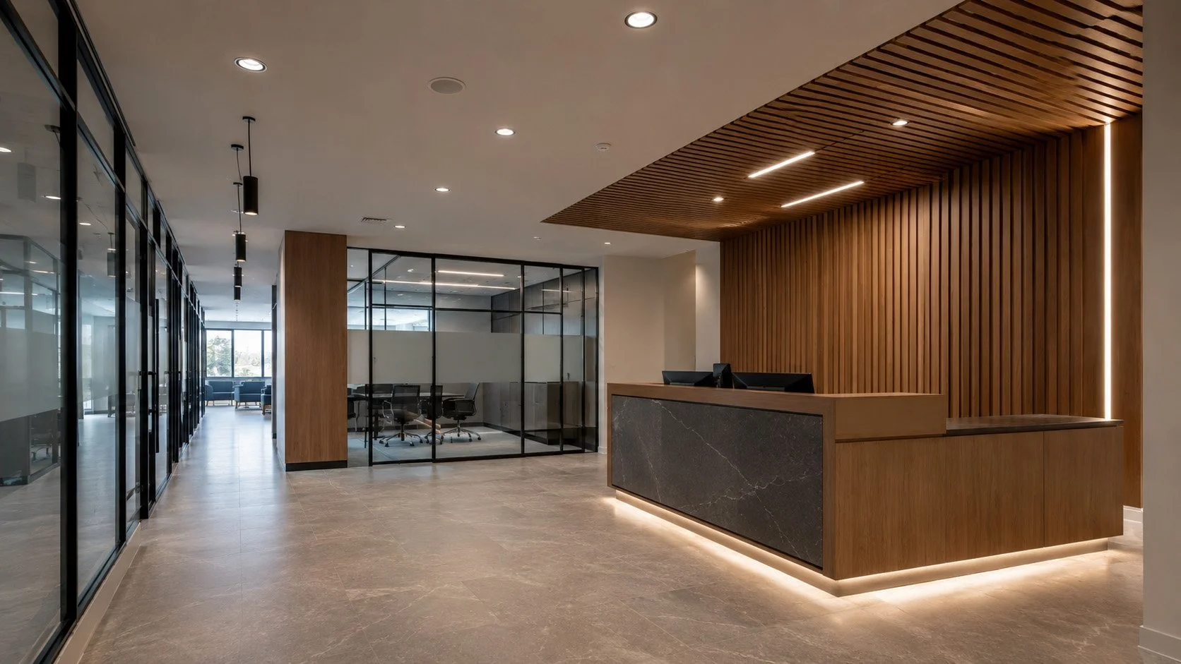 Modern office lobby with a reception desk, wooden wall accent, glass-enclosed meeting room, and seating area visible through glass.