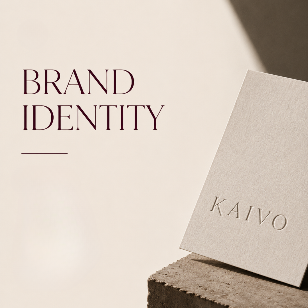 A white card with the words "BRAND IDENTITY" in bold purple letters and a thin purple line underneath, placed on a concrete block with a beige textured paper card with the word "KAIVO" embossed on it, against a neutral background.