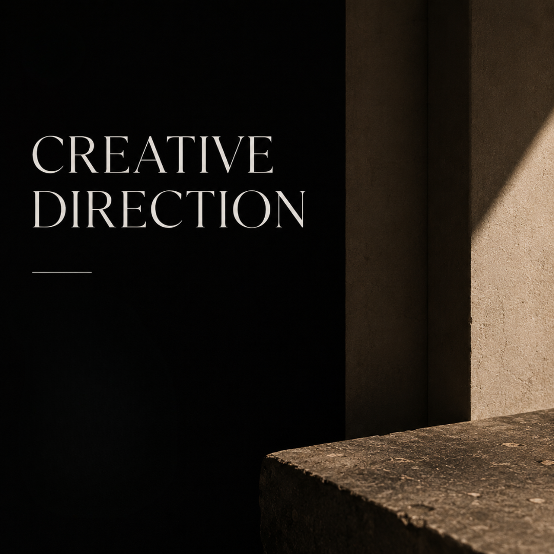 Text reading 'CREATIVE DIRECTION' on a black background next to a beige wall and stone surface