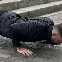 Coach Vince demonstrating a controlled push-up during an outdoor workout