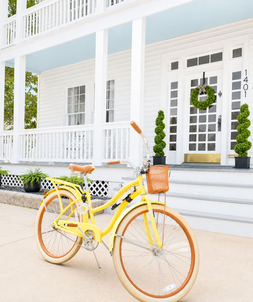 Yellow cruiser bicycle in front of White Magnolia Galveston