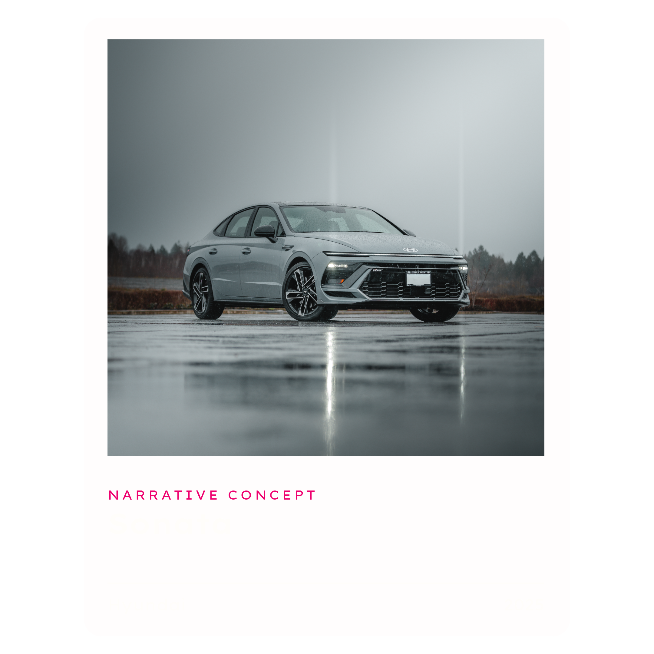 A sleek gray Hyundai car parked on wet pavement in a rainy outdoor setting with a blurred background of trees and overcast sky.