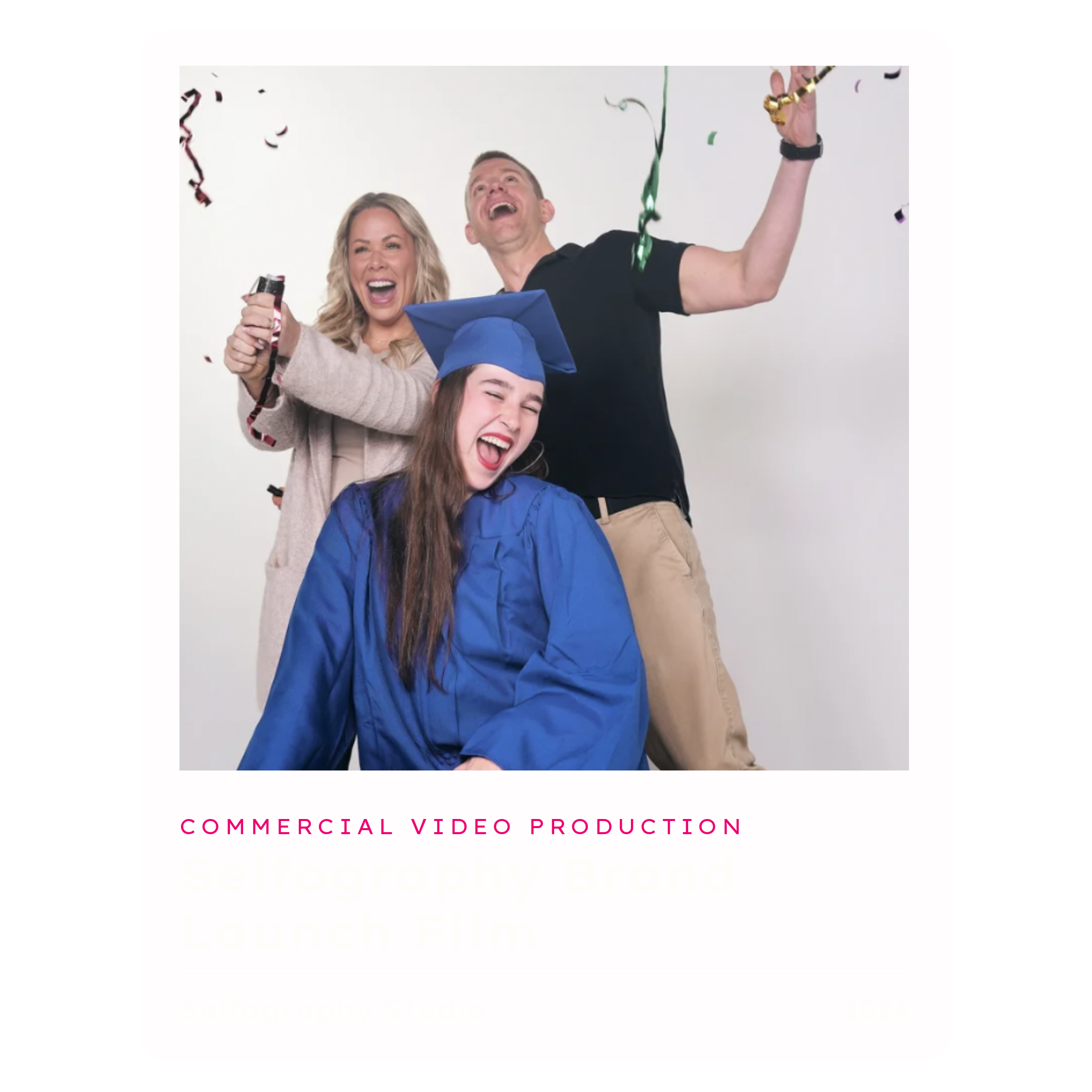 Celebrating graduation with a woman in a beige sweater, a man in a black shirt, and a girl in a blue graduation cap and gown, all joyfully throwing confetti and smiling.