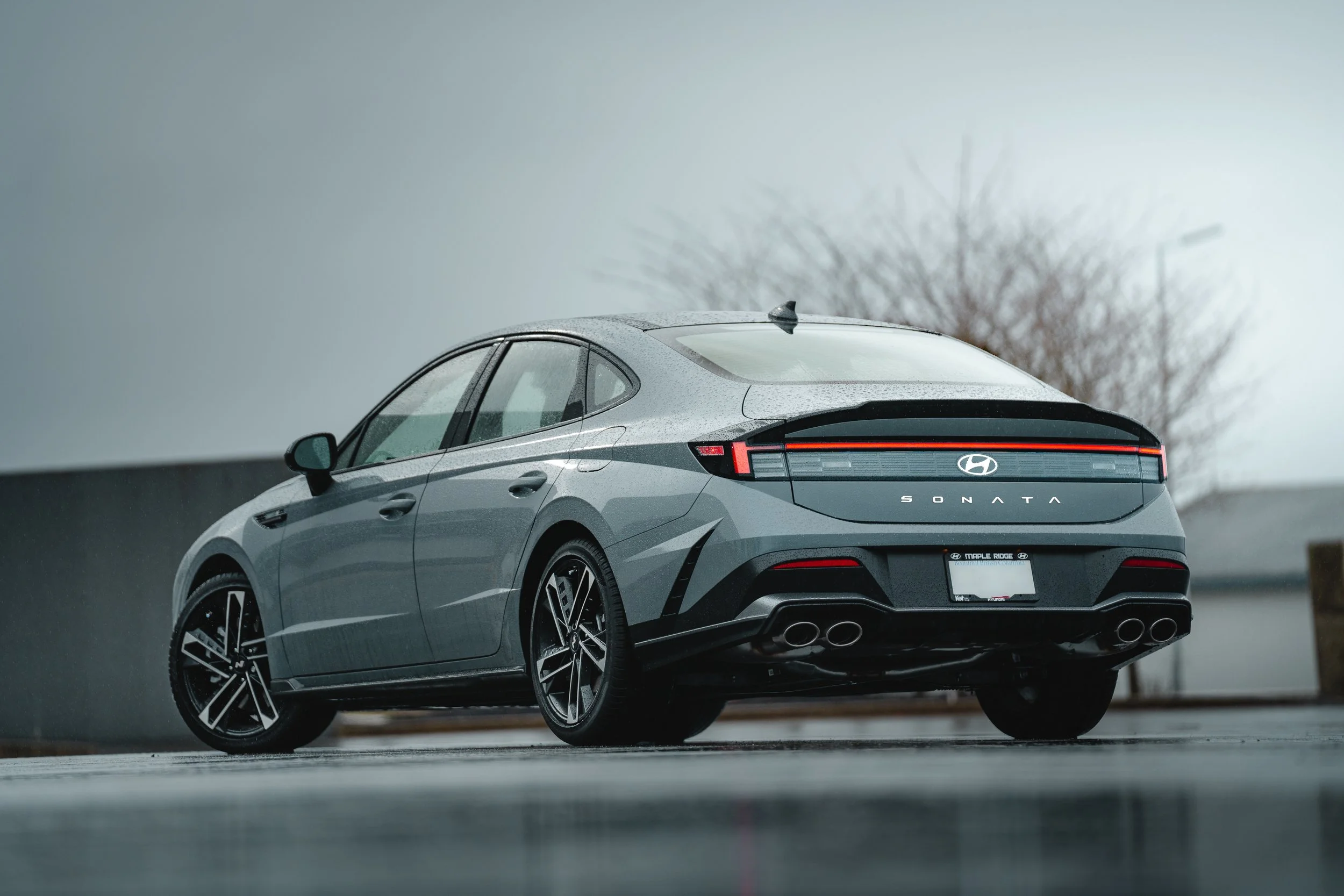 A gray Hyundai Sonata vehicle parked outdoors on a rainy day.