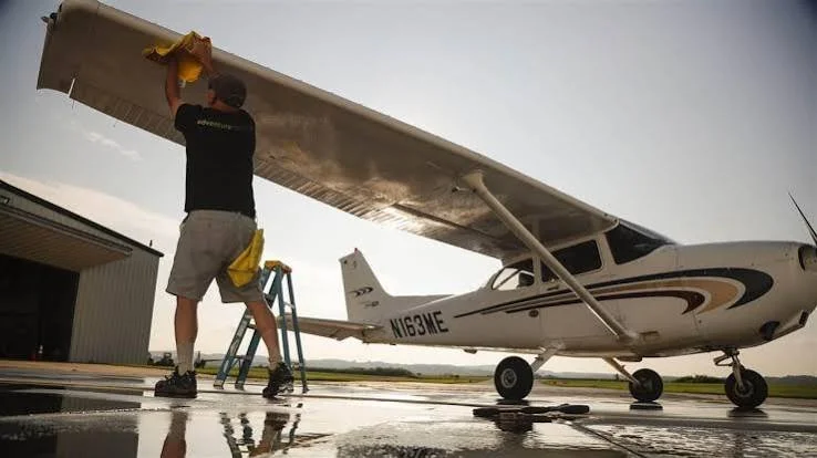Professional aircraft detailing technician cleaning the exterior wing of a Cessna airplane with Stealth Aviation Detailing in Oregon.