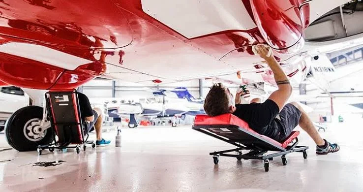 Professional aircraft belly cleaning and exterior detailing service removing grease and grime from a small airplane in Oregon.