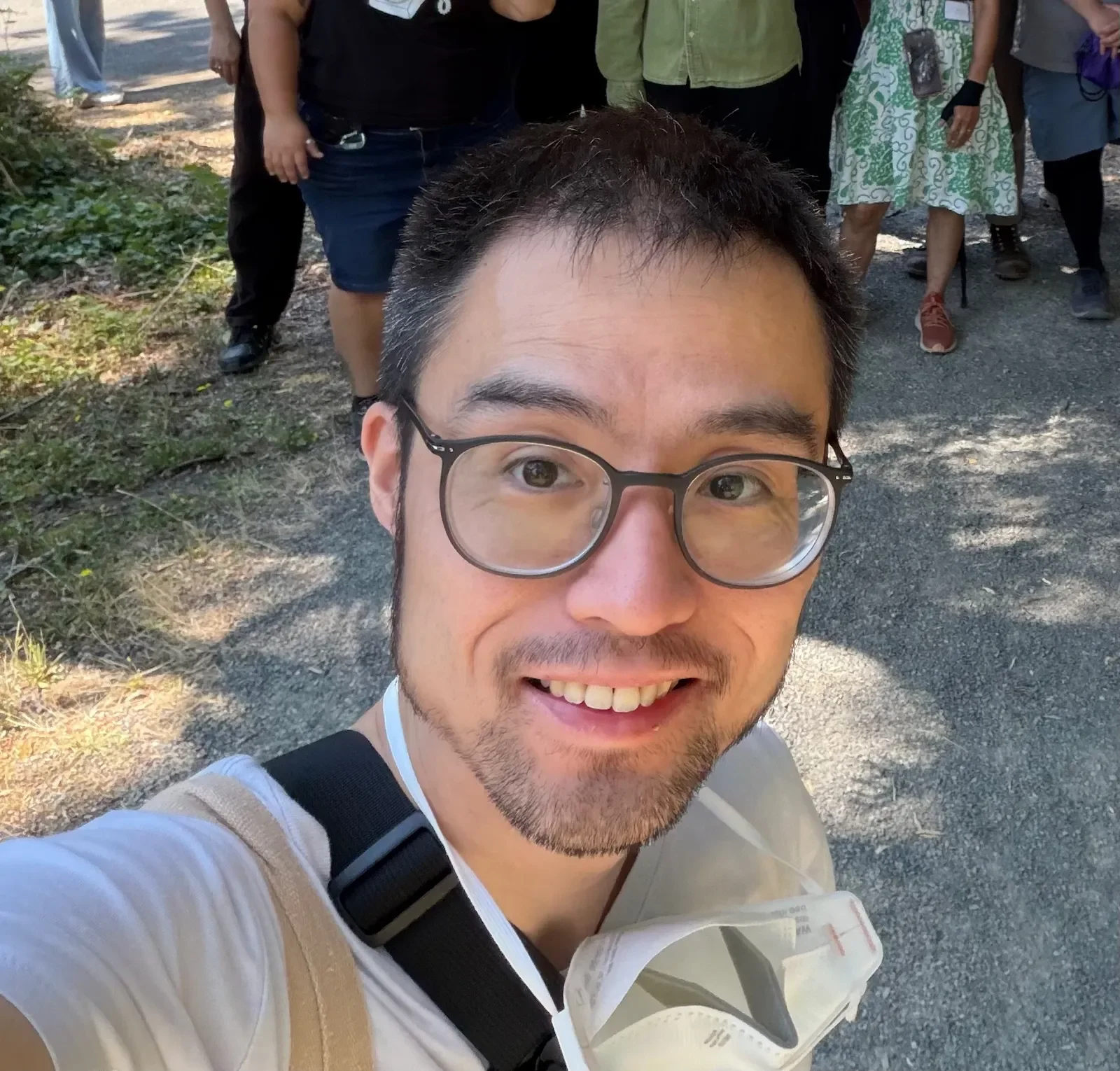 James in front of a group of people (faces not shown) for an EcoCity Action cohost event