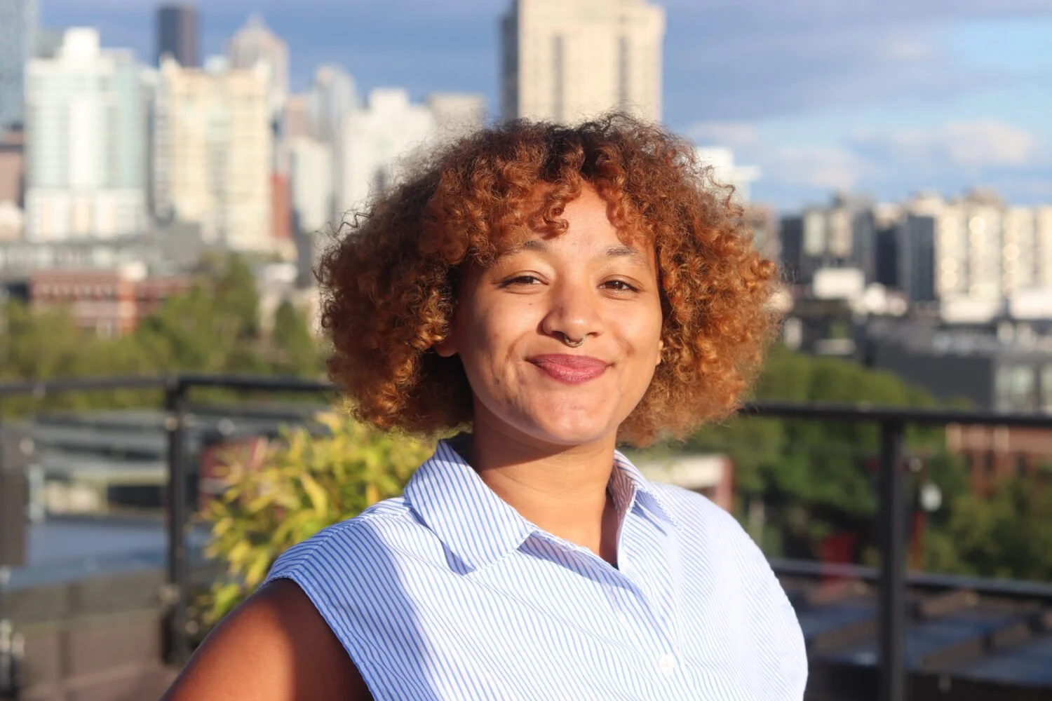 Jazmine on a rooftop in front of the city skyline