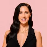 A woman with long dark hair smiling, wearing a black sleeveless top.