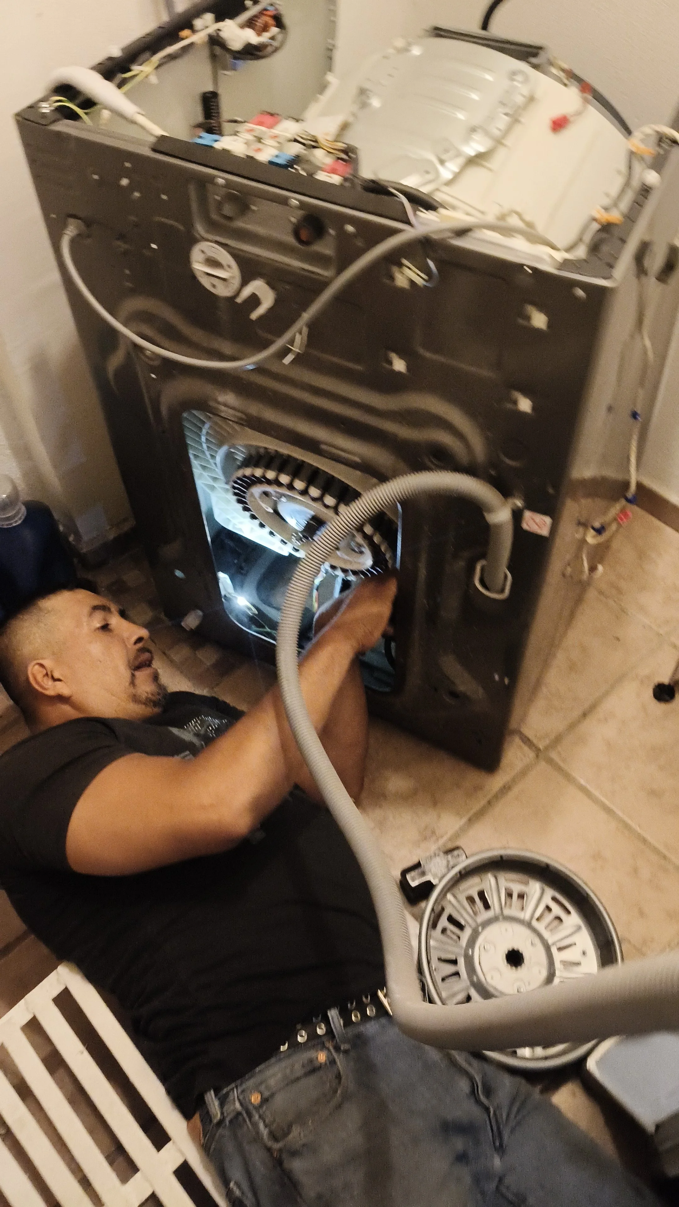 Armando reparando la parte inferior de una lavadora desmontada