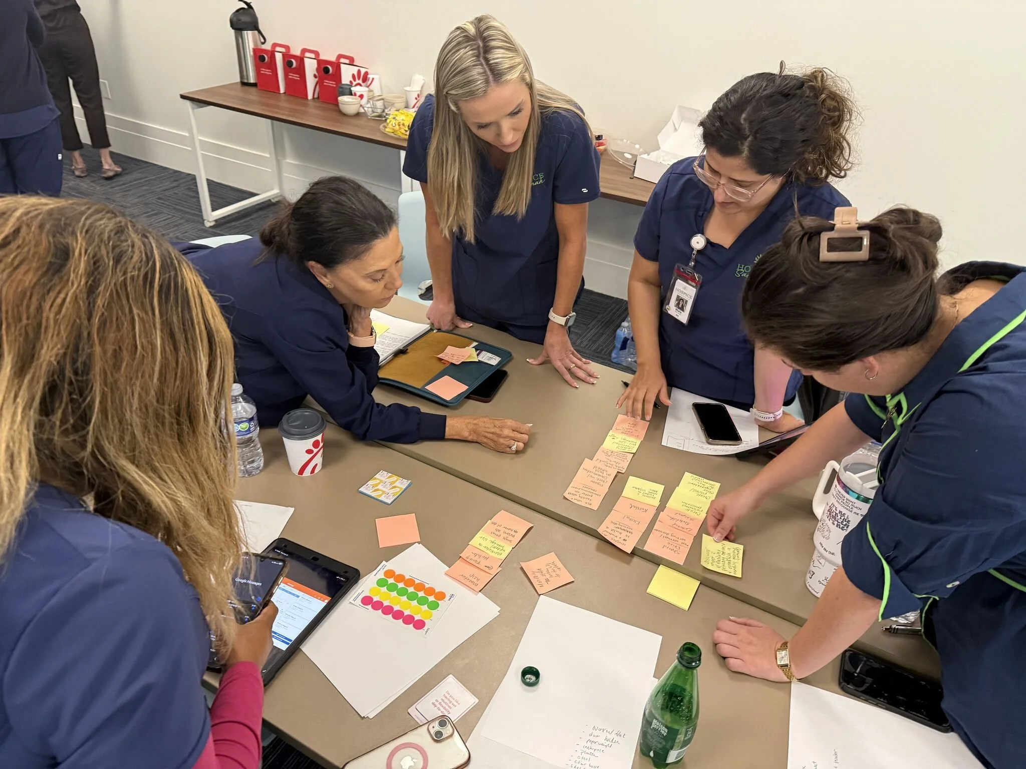 Team members collaborating on a workshop exercise, reviewing notes together at a table.