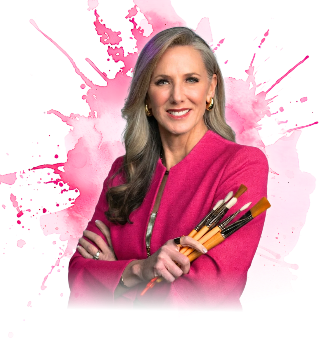 Dr. Heather Hodges, healthcare keynote speaker and creativity researcher, holding paintbrushes in a pink blazer, smiling, with a pink watercolor splash background.
