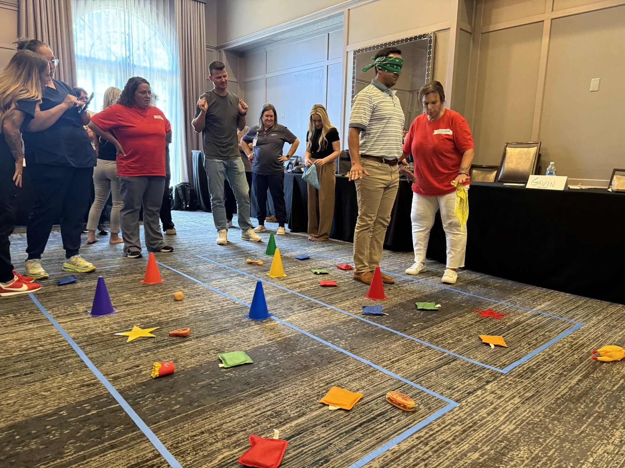Team members participating in a trust-building exercise, guiding a blindfolded colleague through a path of cones.