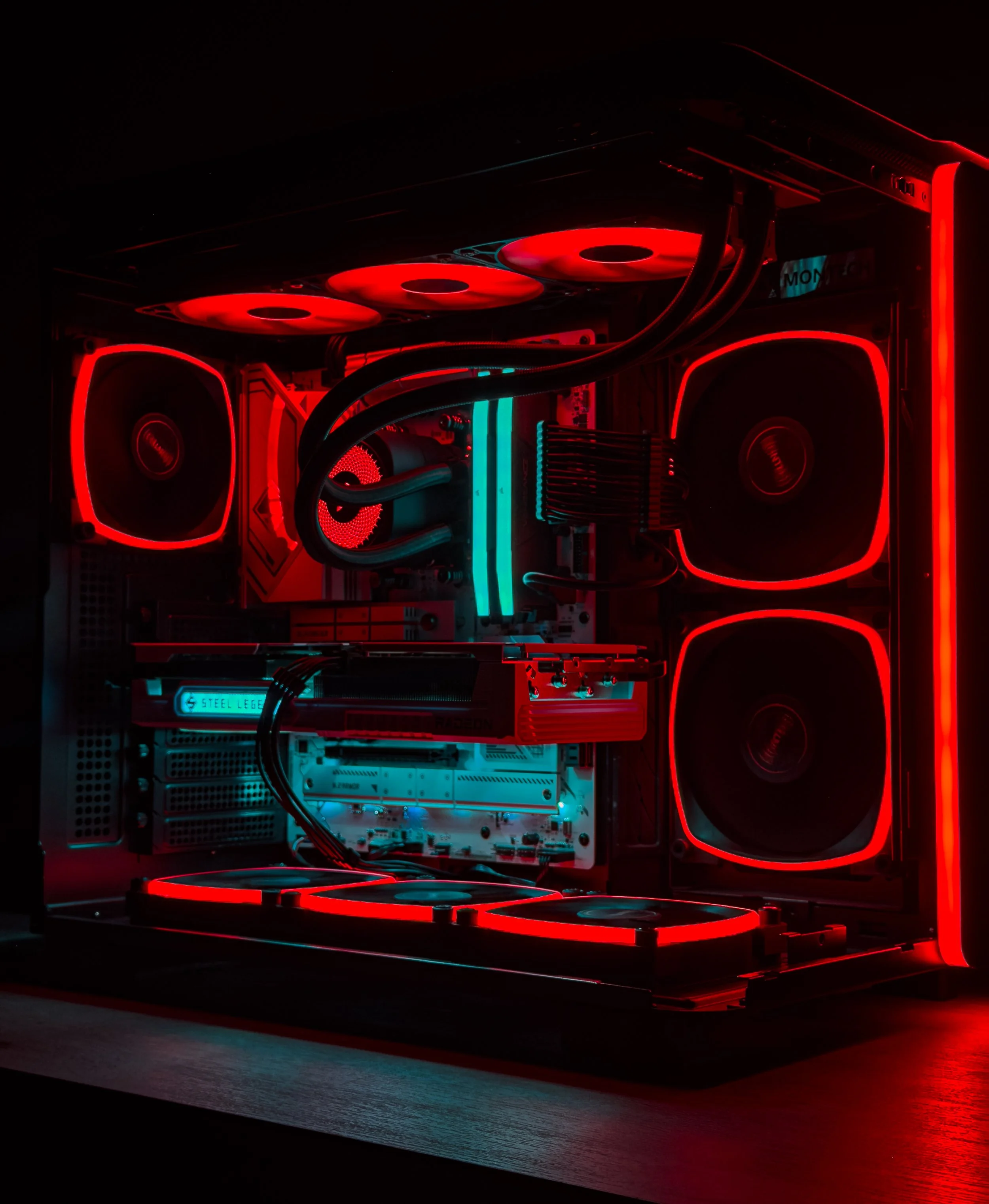 Inside a high-end gaming computer with illuminated red and blue LED lights, featuring cooling fans, a graphics card, and various internal components.