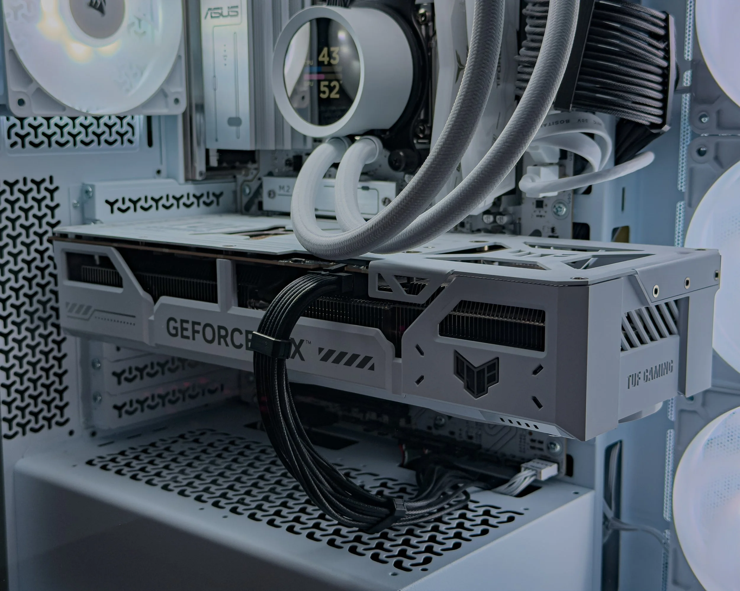Close-up view of a high-end cryptocurrency mining rig with multiple GPUs, radiator, and cooling tubes in a white case.