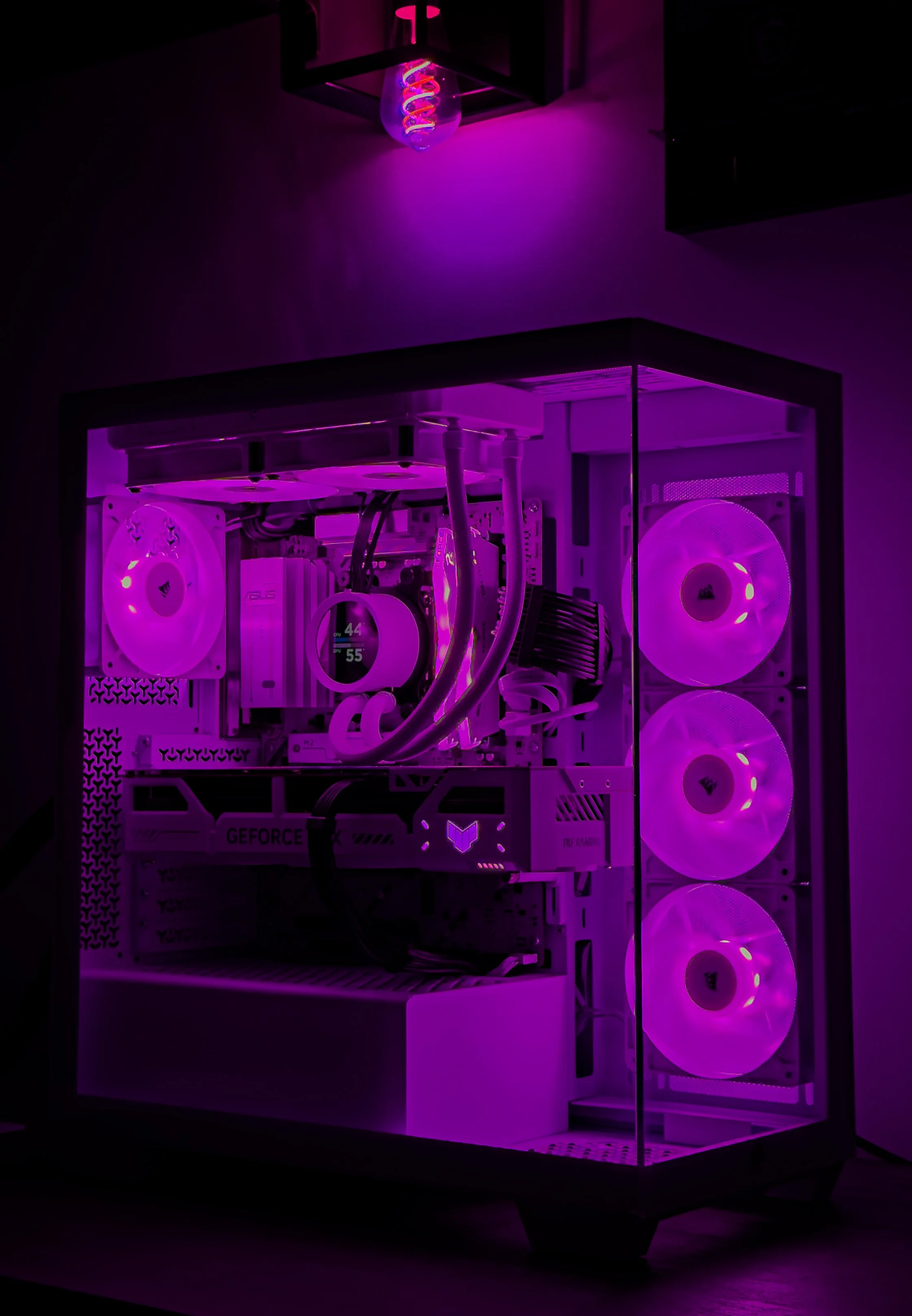 A gaming computer with white components and purple LED lighting, featuring three cooling fans and a liquid cooling system inside a glass case.