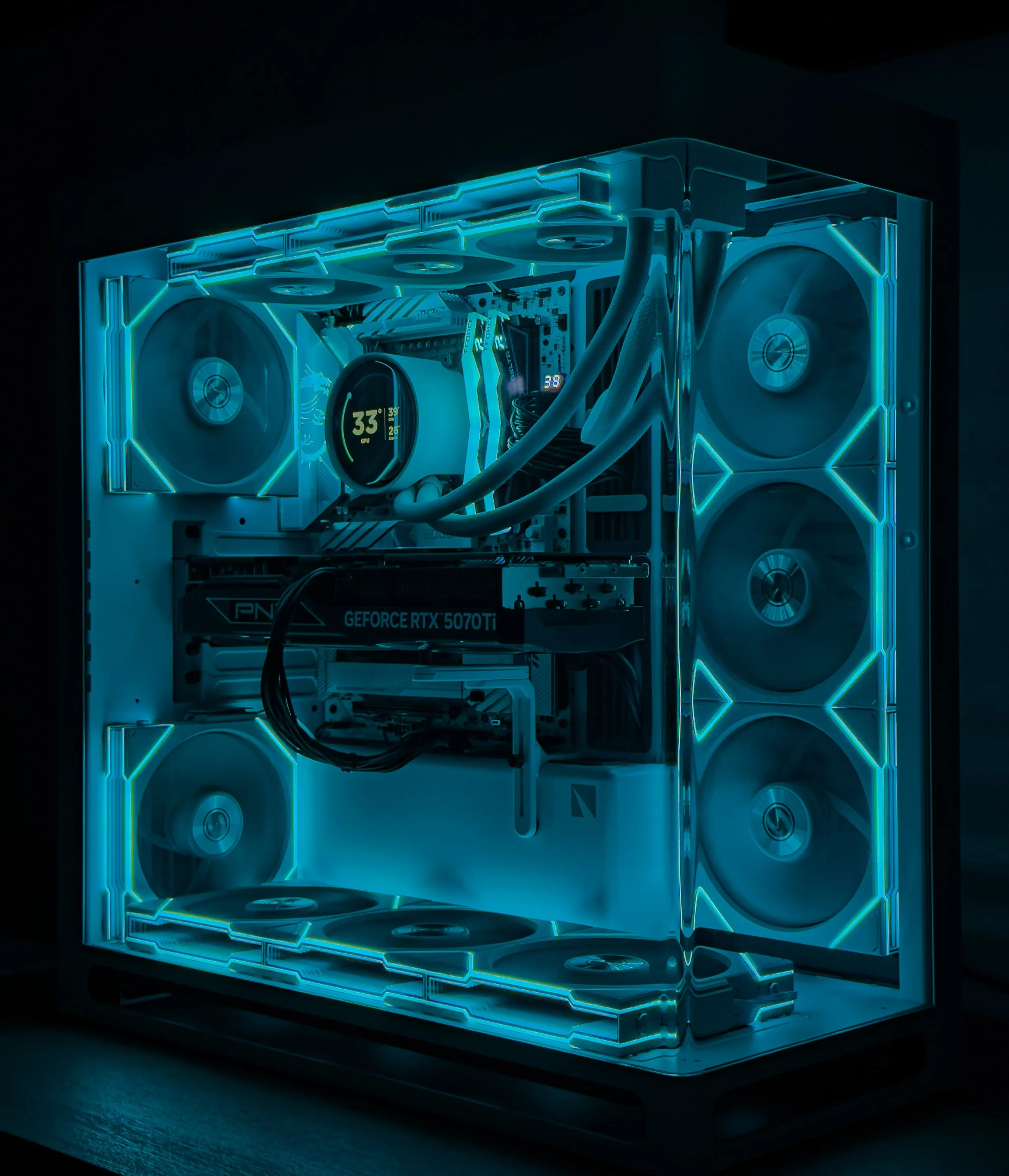 Close-up of a custom gaming PC with illuminated blue LED lighting, multiple fans, and a visible graphics card.